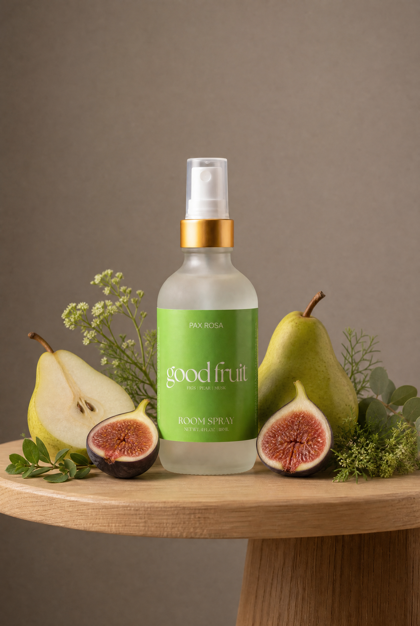 Room spray labeled as"good fruit" on a table with pears and figs.