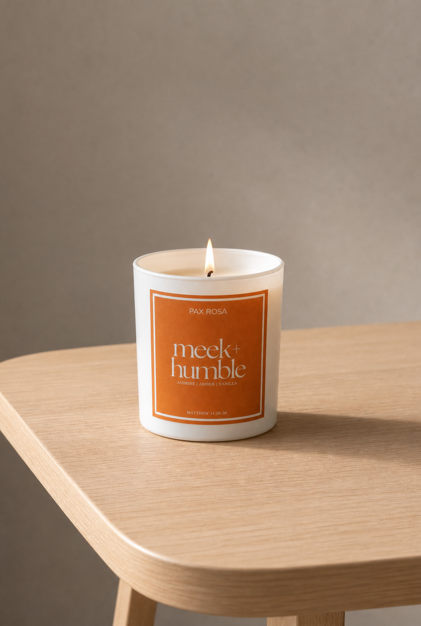 white candle with words "meek and humble" sitting on a table.