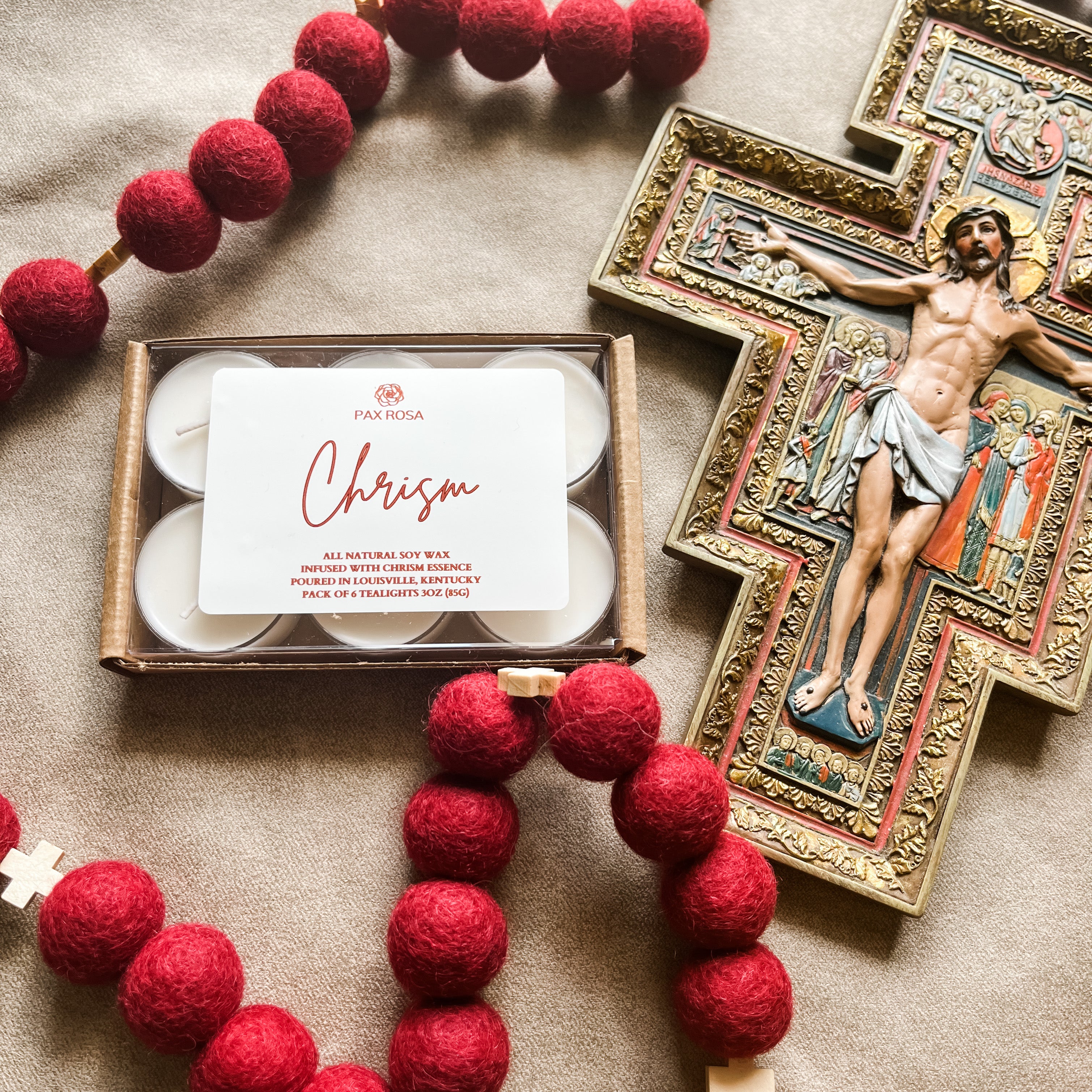 a pack of 6 tealights with the word "chrism" labeled on top. With an image of Jesus on the cross.