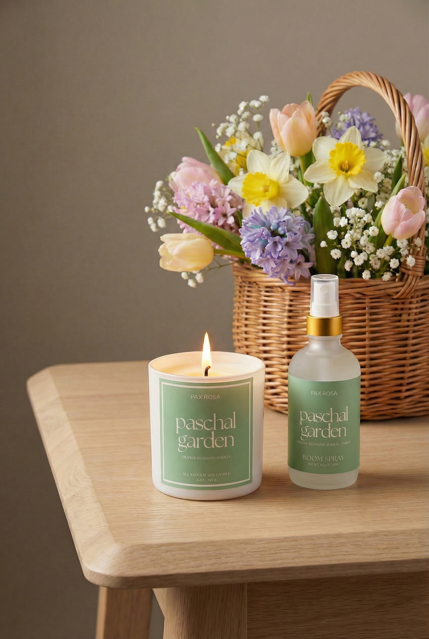 Candle, bottle, and basket of flowers labeled &