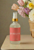 Bottle of pentecost product on a table with a basket of flowers