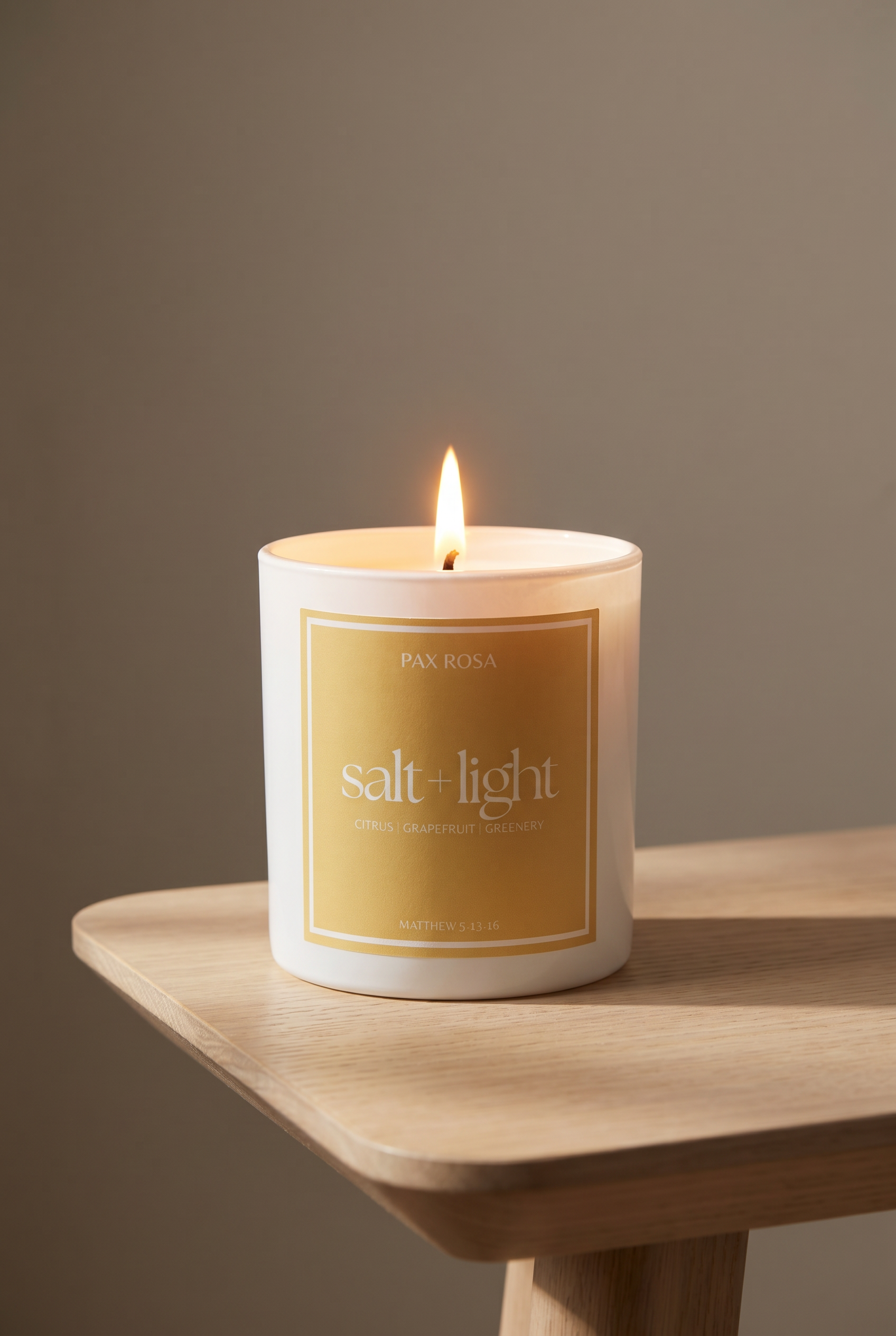 white candle with words "salt and light" on a table