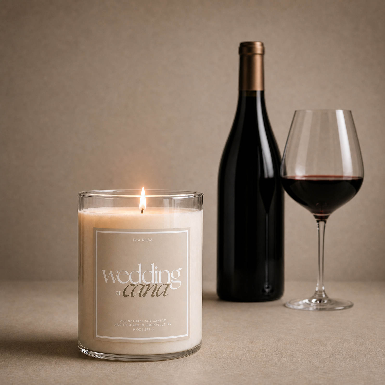 candle lit with label "wedding at cana"  with a bottle and glass of wine