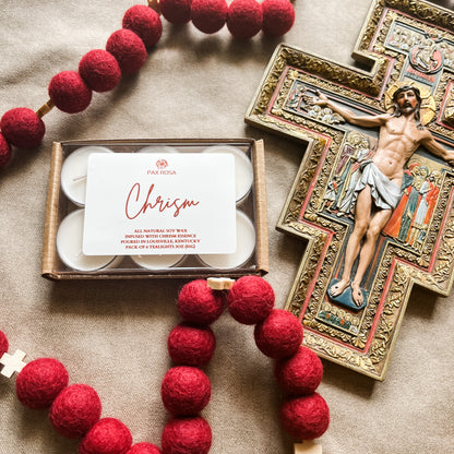 a pack of 6 tealights with the word "chrism" labeled on top. With an image of Jesus on the cross.